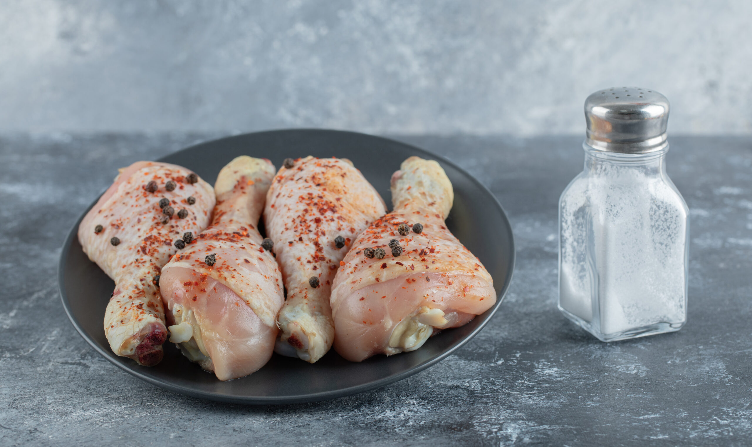 Fresh marinated chicken legs with salt ready to cook
